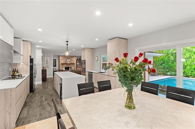 6809 Mentone St, Coral Gables, FL 33146 - dining space with recessed lighting, light wood finished floors, a large fireplace, and baseboards