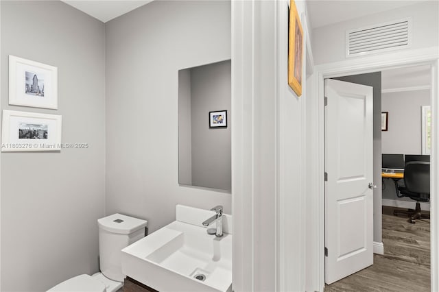 6809 Mentone St, Coral Gables, FL 33146 - bathroom featuring wood finished floors, toilet, a sink, and baseboards