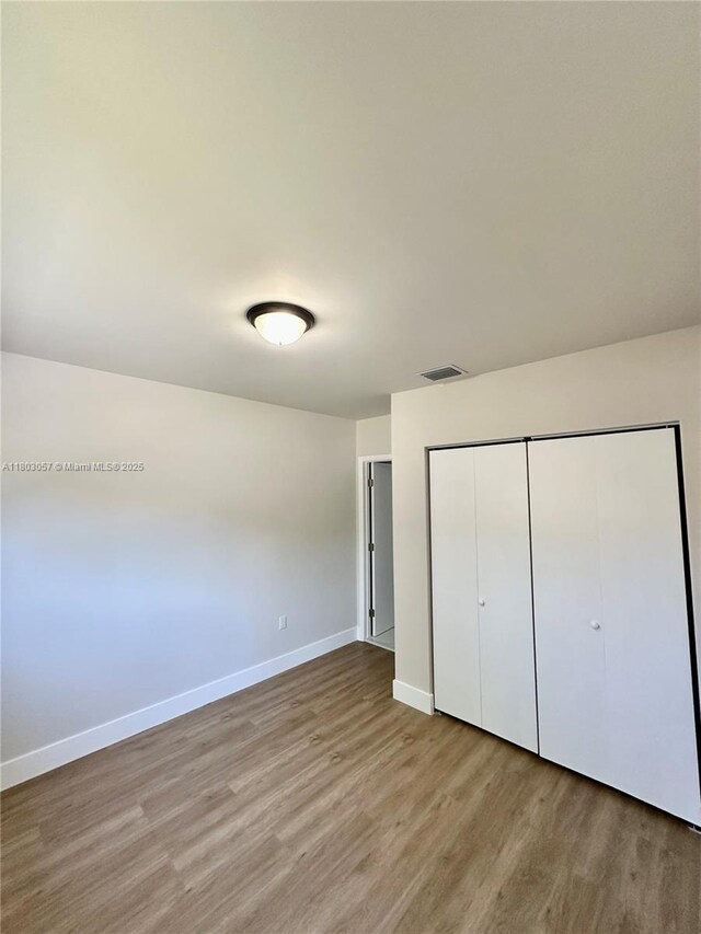 1769 NW 41st St, Miami, FL 33142 - unfurnished bedroom with wood finished floors, baseboards, and a closet