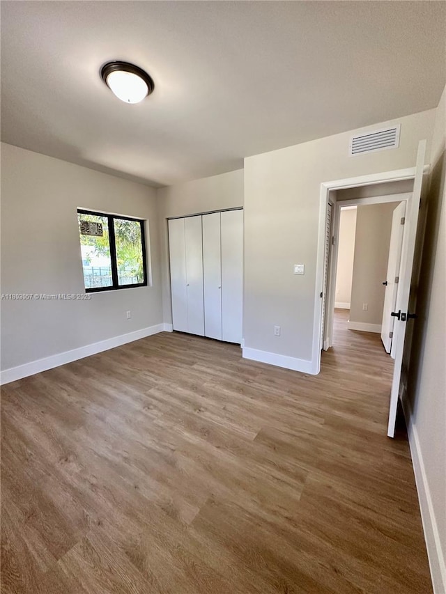 1769 NW 41st St, Miami, FL 33142 - unfurnished bedroom featuring baseboards, a closet, and wood finished floors