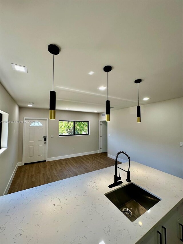 1769 NW 41st St, Miami, FL 33142 - kitchen with a sink, dark wood-style floors, baseboards, light stone counters, and pendant lighting