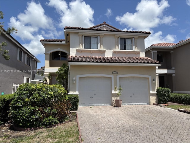 14737 SW 132nd Ct, Miami, FL 33186 - mediterranean / spanish home with a tiled roof, decorative driveway, stucco siding, and an attached garage