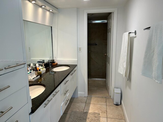 100 Bayview Dr Unit 309, Sunny Isles Beach, FL 33160 - full bathroom with a stall shower, double vanity, tile patterned floors, and baseboards