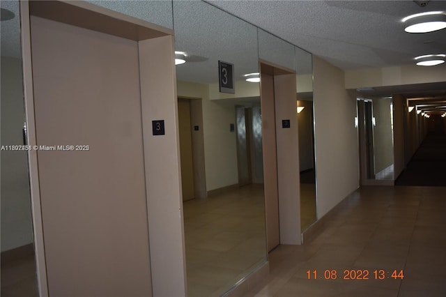 100 Bayview Dr Unit 309, Sunny Isles Beach, FL 33160 - hallway with light tile patterned floors, a textured ceiling, and elevator