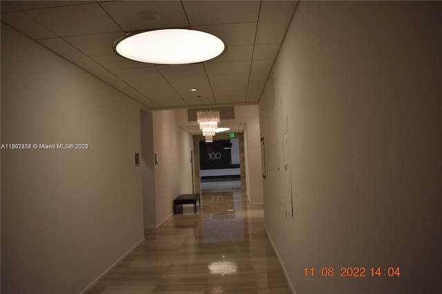 100 Bayview Dr Unit 309, Sunny Isles Beach, FL 33160 - hallway featuring baseboards, a chandelier, and a paneled ceiling