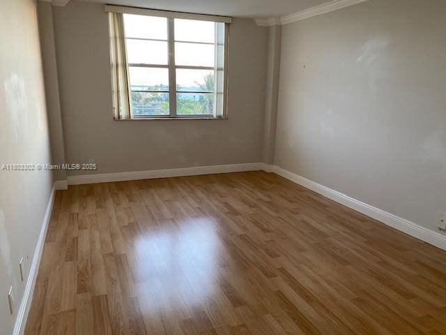 1455 N Treasure Dr Unit 4N, North Bay Village, FL 33141 - spare room with wood finished floors, crown molding, and baseboards