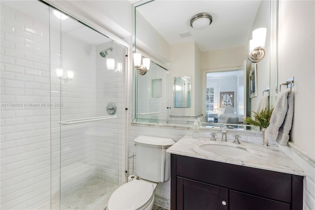 ensuite bathroom with toilet, a stall shower, and vanity