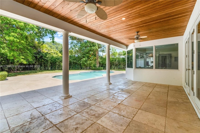 view of pool with ceiling fan, a patio area, and view of scattered trees