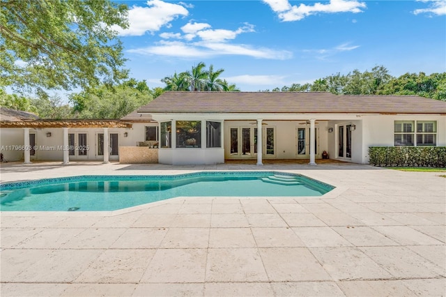 swimming pool featuring french doors, a patio area, and ceiling fan