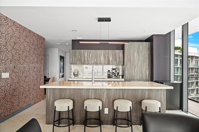 480 NE 31st St Unit 4207, Miami, FL 33137 - kitchen featuring modern cabinets, light countertops, a kitchen bar, a sink, and a wall of windows