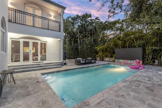 5978 Alton Rd, Miami Beach, FL 33140 - pool at dusk with french doors, a patio area, and an outdoor pool