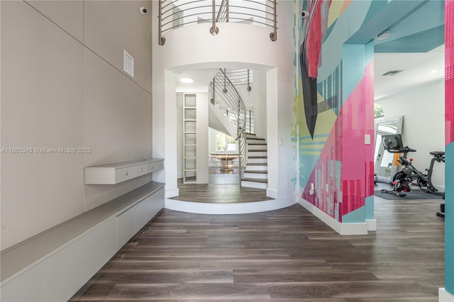 5978 Alton Rd, Miami Beach, FL 33140 - entryway with wood finished floors, stairway, a towering ceiling, baseboards, and arched walkways