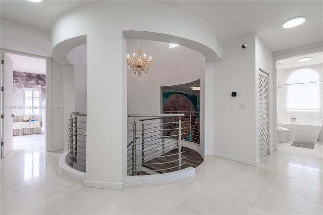 5978 Alton Rd, Miami Beach, FL 33140 - corridor featuring a chandelier, tile patterned flooring, arched walkways, baseboards, and an upstairs landing