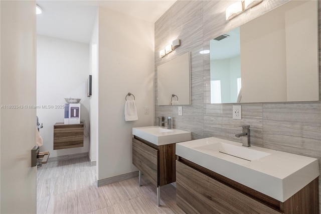 5978 Alton Rd, Miami Beach, FL 33140 - bathroom featuring tile walls, two vanities, backsplash, and baseboards