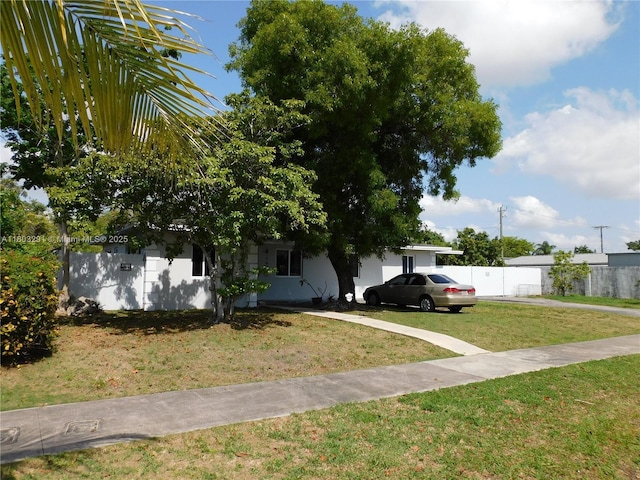 view of property hidden behind natural elements with stucco siding