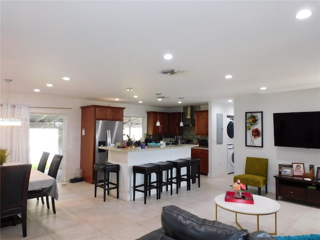 living area featuring stacked washer / dryer, recessed lighting, and light tile patterned floors