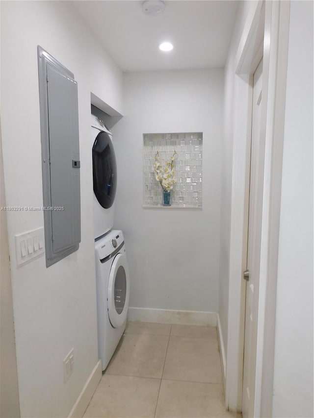 laundry room featuring stacked washer and clothes dryer, electric panel, light tile patterned floors, baseboards, and recessed lighting