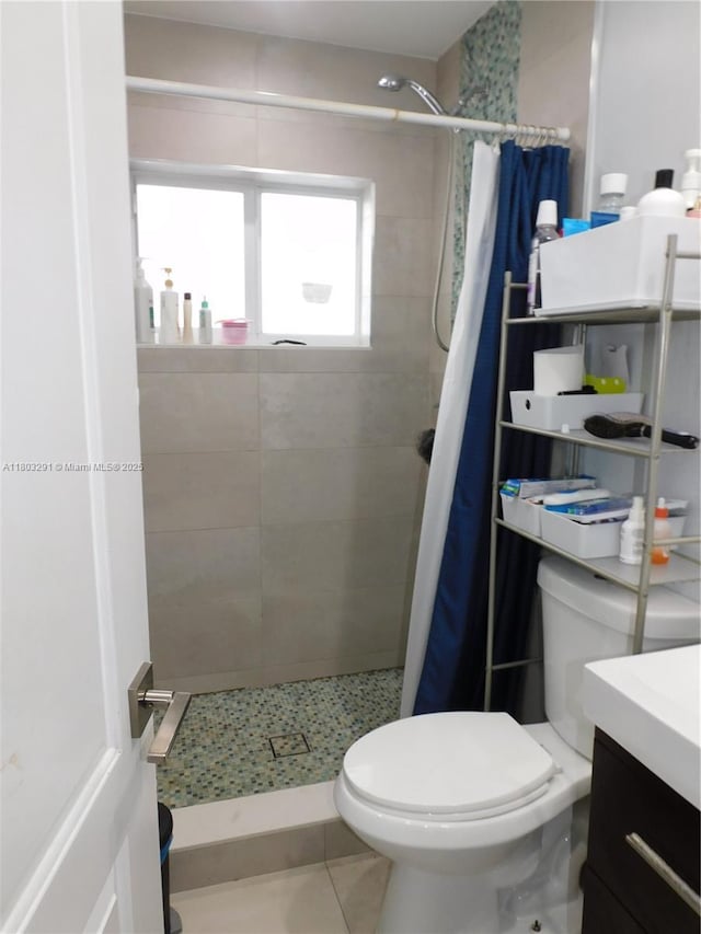 bathroom featuring a stall shower, toilet, tile patterned floors, and vanity