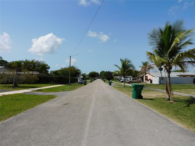 view of asphalt road with street lighting and sidewalks