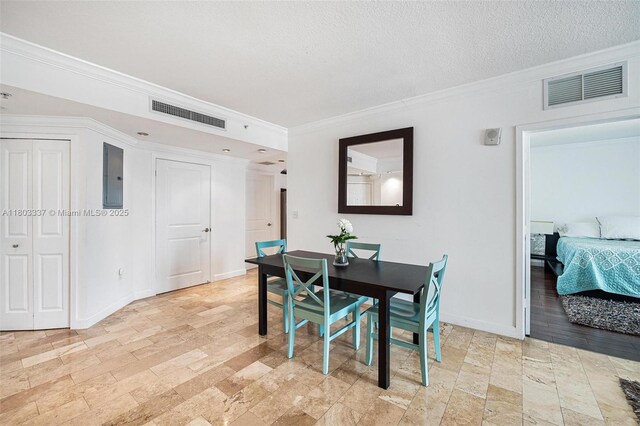 170 SE 14th St Unit 2805, Miami, FL 33131 - dining area featuring ornamental molding, electric panel, stone tile floors, baseboards, and a textured ceiling