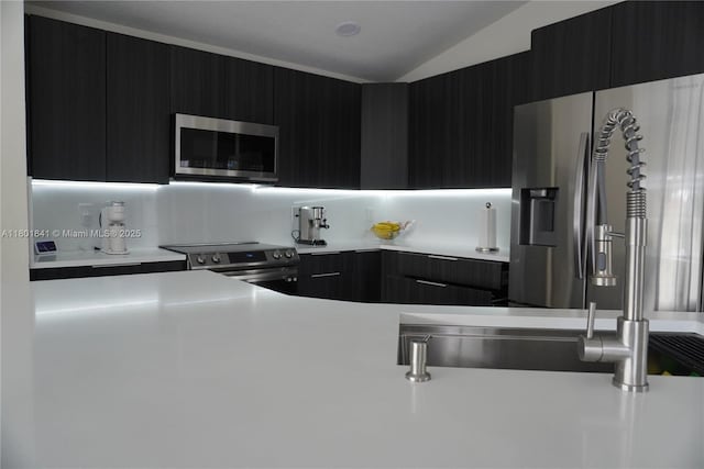 1132 Cedar Falls Dr, Weston, FL 33327 - kitchen with stainless steel appliances, dark cabinetry, modern cabinets, light countertops, and lofted ceiling