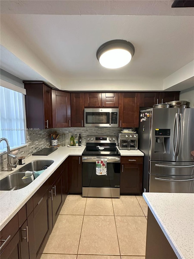 13707 Kendale Lakes Cir Unit 110, Miami, FL 33183 - kitchen with appliances with stainless steel finishes, decorative backsplash, light tile patterned floors, and dark brown cabinetry