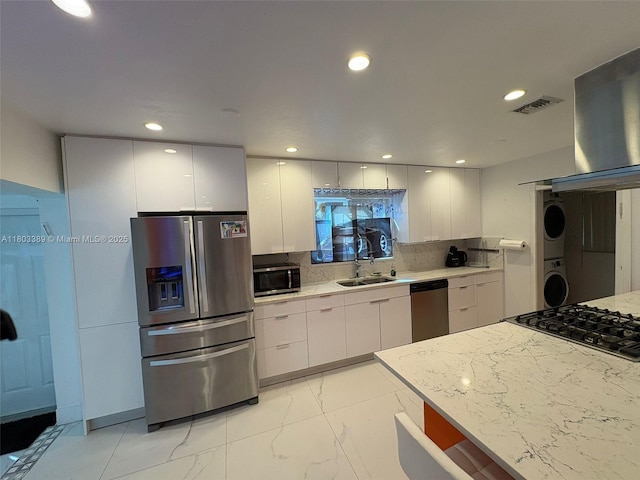 963 Nautilus Isle, Dania Beach, FL 33004 - kitchen with appliances with stainless steel finishes, stacked washer and clothes dryer, white cabinets, modern cabinets, and recessed lighting