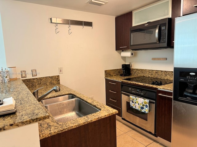 9066 SW 73rd Ct Unit 1703, Miami, FL 33156 - kitchen featuring stainless steel appliances, a sink, dark brown cabinetry, light stone counters, and glass insert cabinets