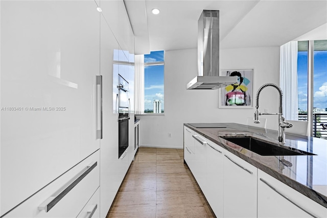 1445 16th St Unit Ph-4, Miami Beach, FL 33139 - kitchen featuring island range hood, a sink, black oven, white cabinets, and recessed lighting