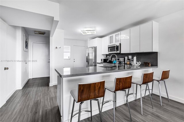 1780 NE 191st St Unit 501-2, Miami, FL 33179 - kitchen featuring stainless steel appliances, dark wood-type flooring, a peninsula, and a breakfast bar area