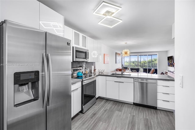 1780 NE 191st St Unit 501-2, Miami, FL 33179 - kitchen with stainless steel appliances, a sink, white cabinets, and light wood finished floors