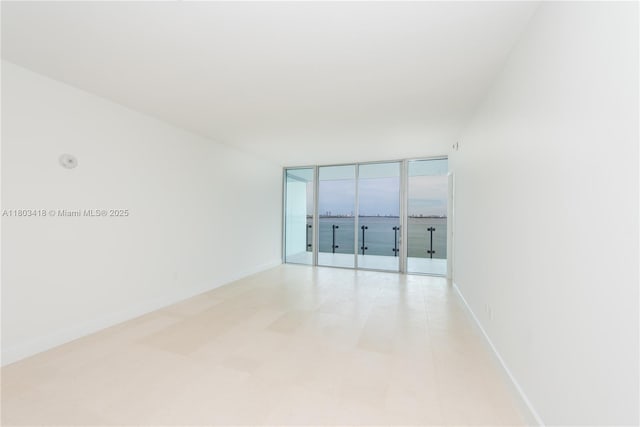 700 NE 26th Ter Unit 903, Miami, FL 33137 - unfurnished room featuring baseboards and expansive windows