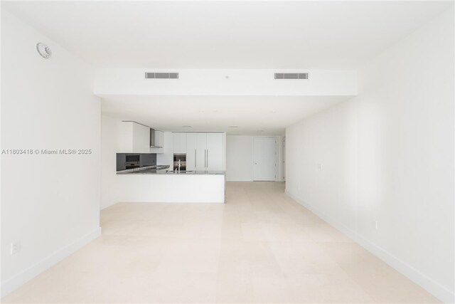 700 NE 26th Ter Unit 903, Miami, FL 33137 - unfurnished living room featuring baseboards and a sink