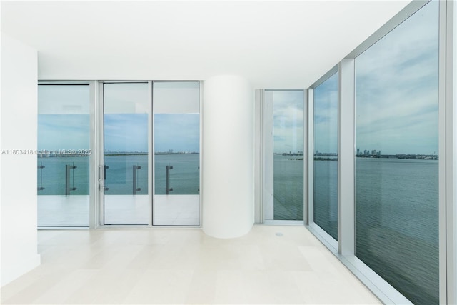 700 NE 26th Ter Unit 903, Miami, FL 33137 - unfurnished room with floor to ceiling windows, a water view, and tile patterned floors