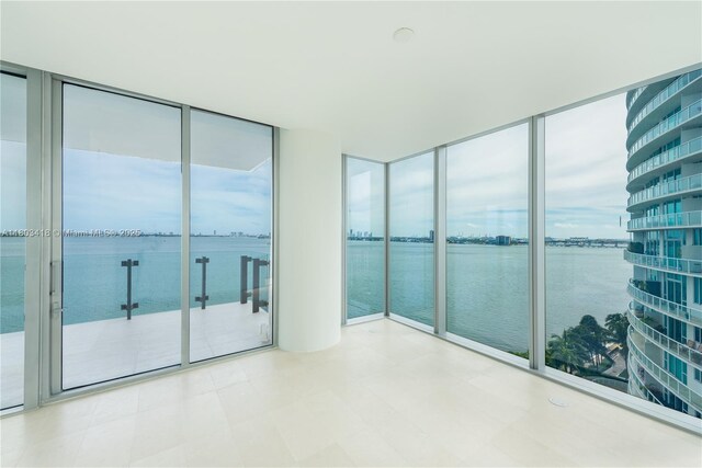 700 NE 26th Ter Unit 903, Miami, FL 33137 - empty room with a water view, floor to ceiling windows, plenty of natural light, and tile patterned floors