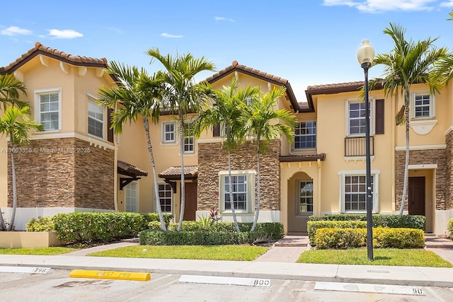 9153 SW 227th St Unit 3, Cutler Bay, FL 33190 - view of front facade featuring stucco siding, a tile roof, stone siding, and uncovered parking