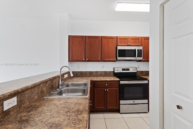 9153 SW 227th St Unit 3, Cutler Bay, FL 33190 - kitchen featuring appliances with stainless steel finishes, a sink, light tile patterned flooring, and dark countertops