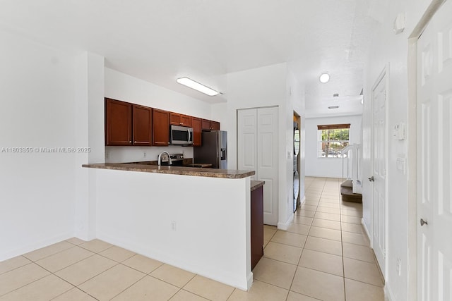 9153 SW 227th St Unit 3, Cutler Bay, FL 33190 - kitchen with appliances with stainless steel finishes, light tile patterned flooring, dark countertops, a peninsula, and a sink