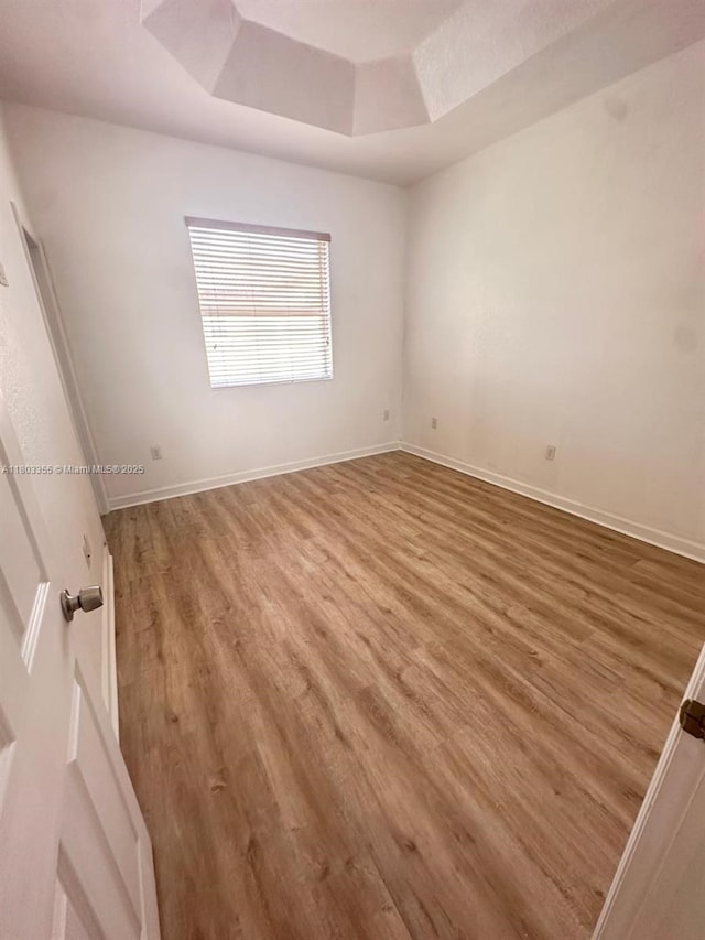 9153 SW 227th St Unit 3, Cutler Bay, FL 33190 - empty room with wood finished floors, baseboards, and a tray ceiling