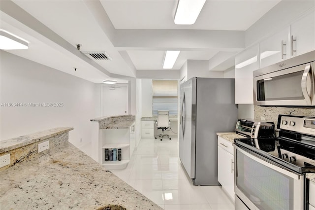 9650 S Ocean Dr Unit 2003, Jensen Beach, FL 34957 - kitchen with appliances with stainless steel finishes, white cabinets, light tile patterned flooring, light stone counters, and backsplash