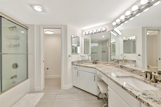 9650 S Ocean Dr Unit 2003, Jensen Beach, FL 34957 - full bath with toilet, tile patterned floors, baseboards, bath / shower combo with glass door, and double vanity