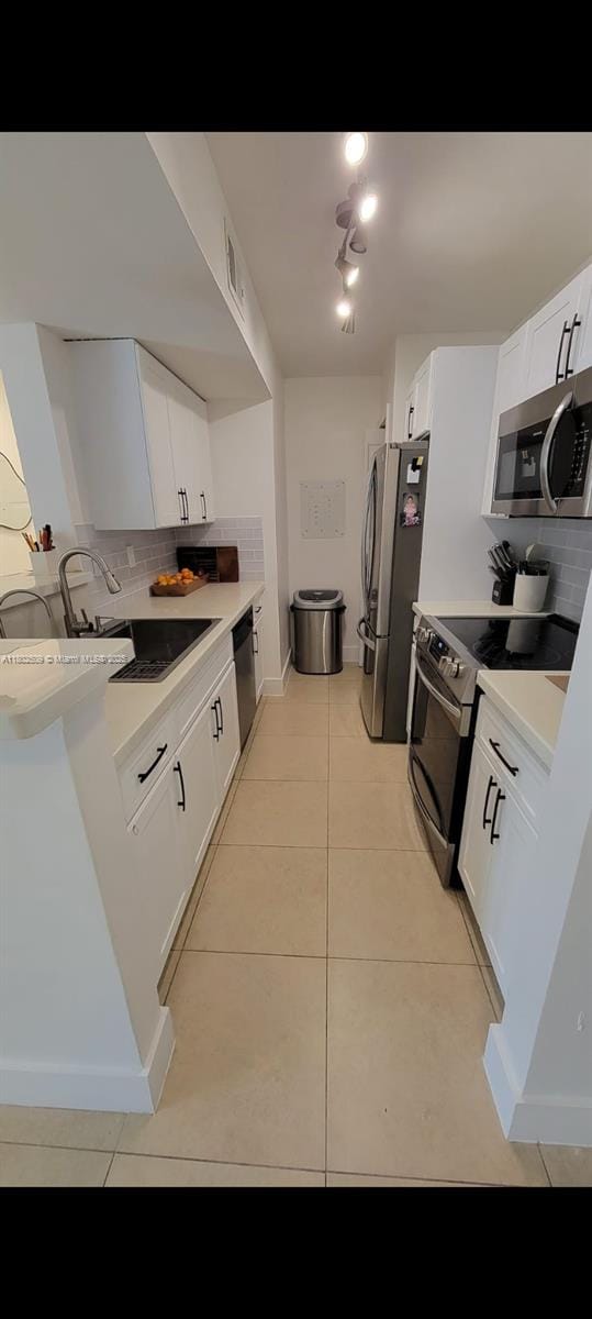 10670 SW 156th Pl Unit 313, Miami, FL 33196 - kitchen with appliances with stainless steel finishes, backsplash, light countertops, and light tile patterned floors
