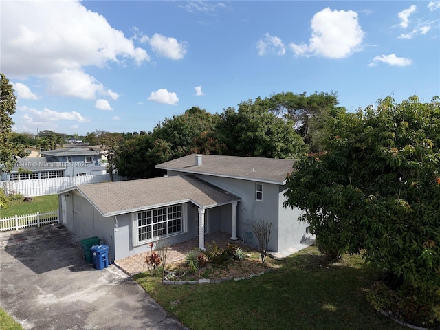 1345 NE 199th St, Miami, FL 33179 - view of home's exterior featuring stucco siding, roof with shingles, and asphalt driveway