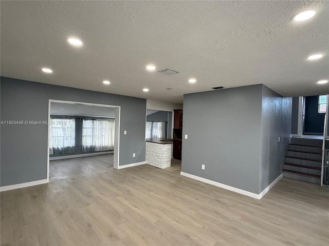 1345 NE 199th St, Miami, FL 33179 - unfurnished living room with a textured ceiling, light wood finished floors, baseboards, stairway, and recessed lighting