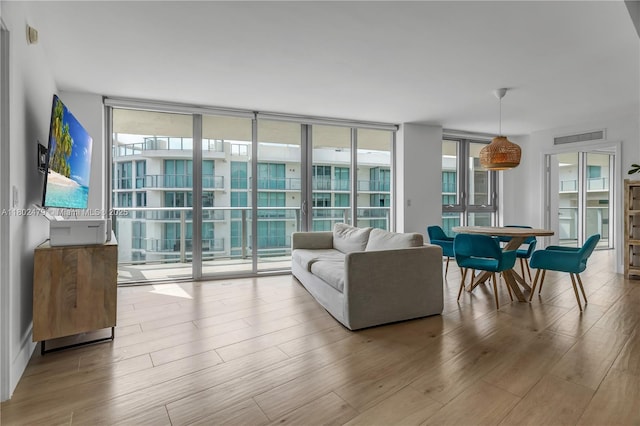 6620 Indian Creek Dr Unit 619, Miami Beach, FL 33141 - living area featuring floor to ceiling windows, healthy amount of natural light, and wood finished floors