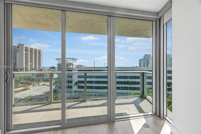 6620 Indian Creek Dr Unit 619, Miami Beach, FL 33141 - doorway with plenty of natural light, a city view, a wall of windows, and wood finished floors