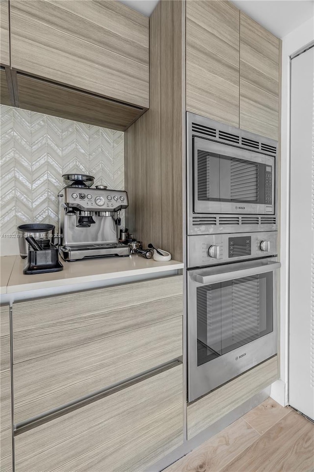 6620 Indian Creek Dr Unit 619, Miami Beach, FL 33141 - kitchen with stainless steel appliances, modern cabinets, light countertops, decorative backsplash, and light brown cabinets