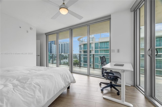 6620 Indian Creek Dr Unit 619, Miami Beach, FL 33141 - bedroom featuring expansive windows, access to exterior, a desk, and wood finished floors