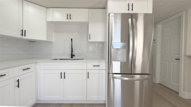 5531 SW 38th St, West Park, FL 33023 - kitchen featuring stainless steel fridge, a sink, white cabinets, tasteful backsplash, and light countertops
