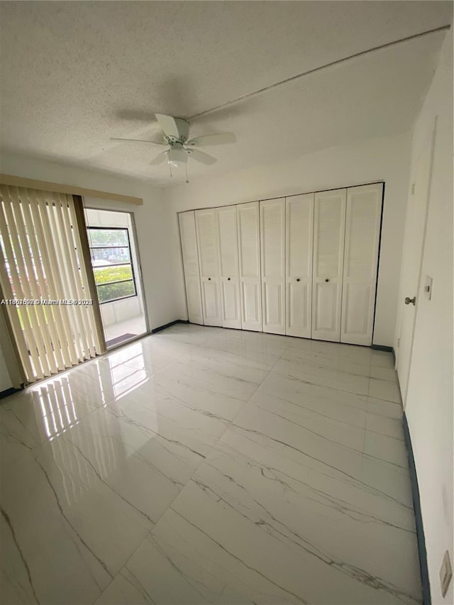 111 Tilford F Unit 111, Deerfield Beach, FL 33442 - unfurnished bedroom with light marble finish floors, a ceiling fan, a textured ceiling, and access to outside